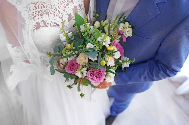 Groom and bride with beautiful bouquet closeup
