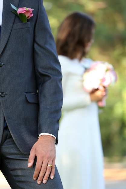 Groom and bride with wedding bouquet on nature background