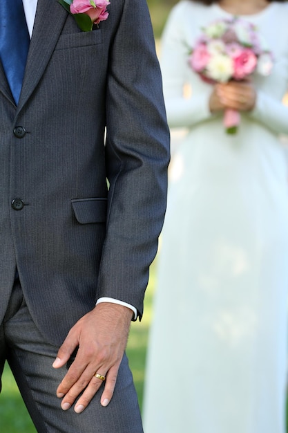 Groom and bride with wedding bouquet on nature background