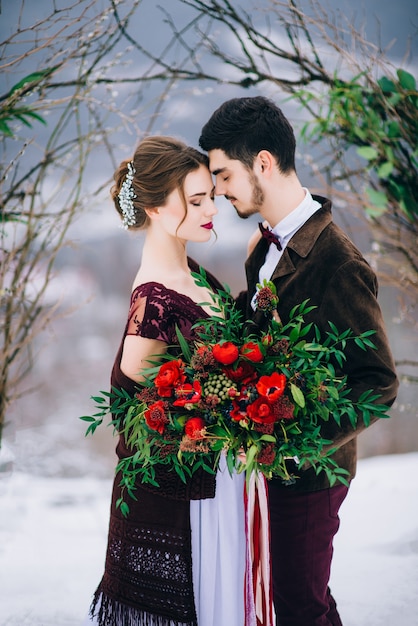 Groom in a brown and bride in the mountains Carpathians