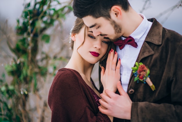 Groom in a brown and bride in the mountains Carpathians