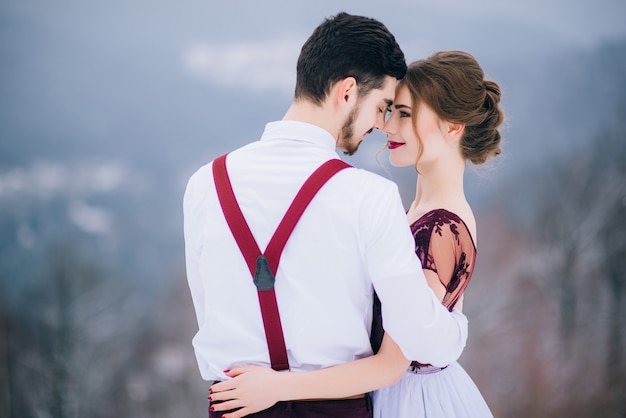 Groom in a brown and bride in the mountains Carpathians