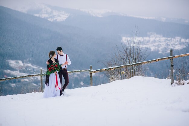 Groom in a brown and bride in the mountains Carpathians