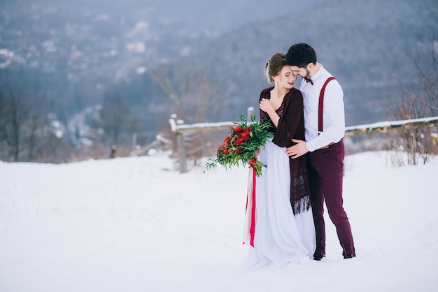 Groom in a brown and bride in the mountains Carpathians