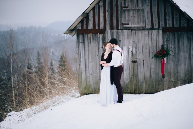 Photo groom in a brown and bride in the mountains carpathians