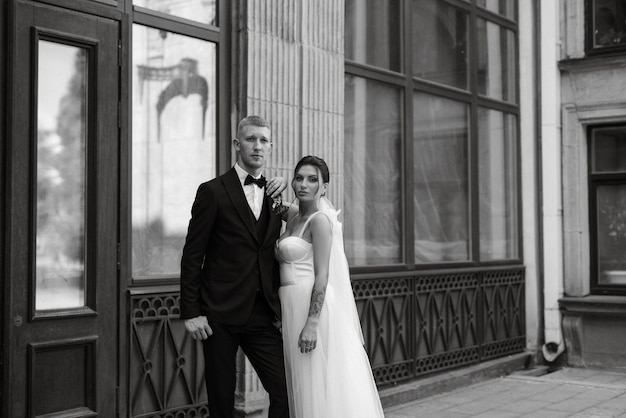 The groom in a brown suit and the bride in a white dress