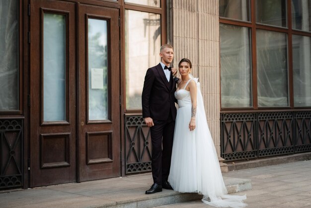 The groom in a brown suit and the bride in a white dress