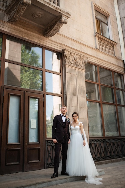 The groom in a brown suit and the bride in a white dress