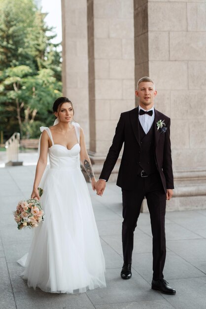 The groom in a brown suit and the bride in a white dress