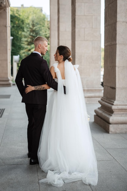 The groom in a brown suit and the bride in a white dress