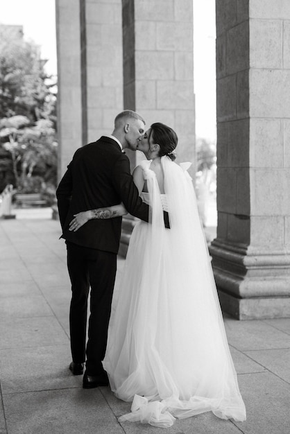 The groom in a brown suit and the bride in a white dress