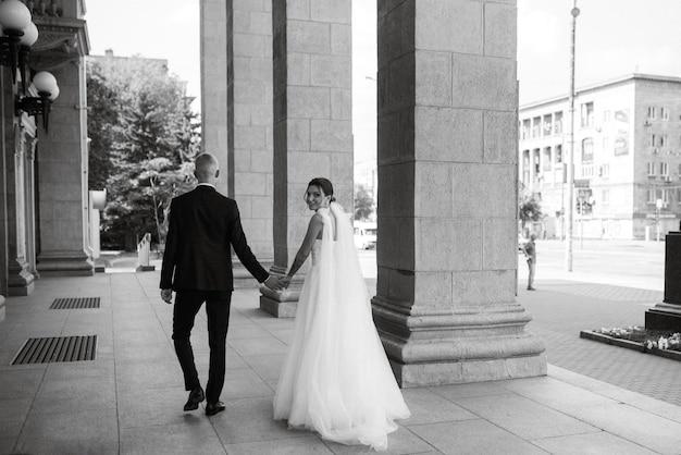 The groom in a brown suit and the bride in a white dress