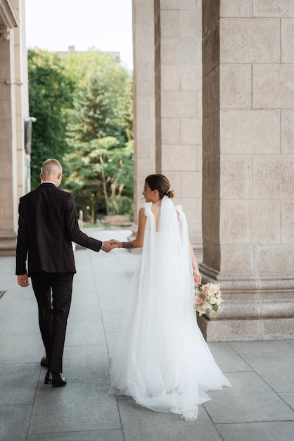 The groom in a brown suit and the bride in a white dress