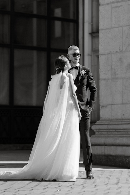 The groom in a brown suit and the bride in a white dress