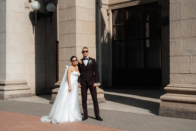 The groom in a brown suit and the bride in a white dress