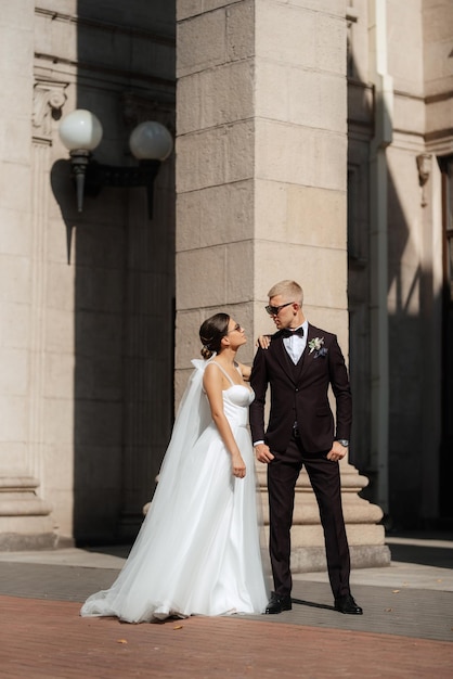 The groom in a brown suit and the bride in a white dress