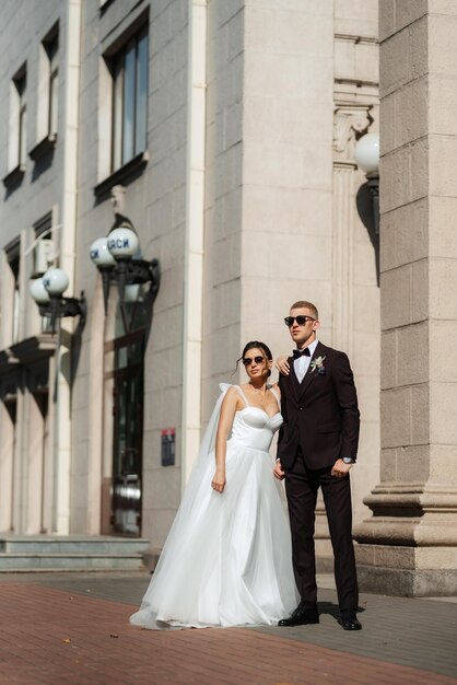 The groom in a brown suit and the bride in a white dress