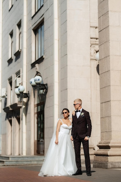 The groom in a brown suit and the bride in a white dress