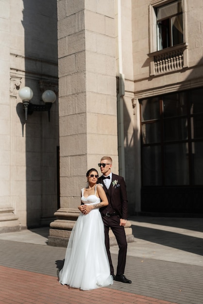 The groom in a brown suit and the bride in a white dress