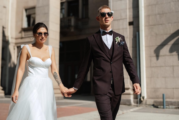 The groom in a brown suit and the bride in a white dress