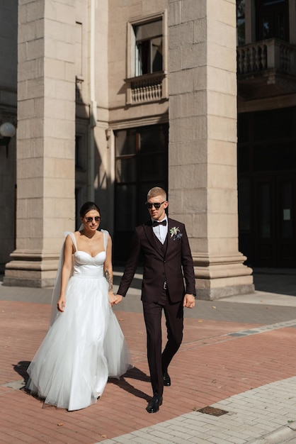 The groom in a brown suit and the bride in a white dress