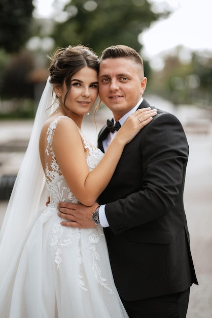 the groom in a brown suit and the bride in a white dress