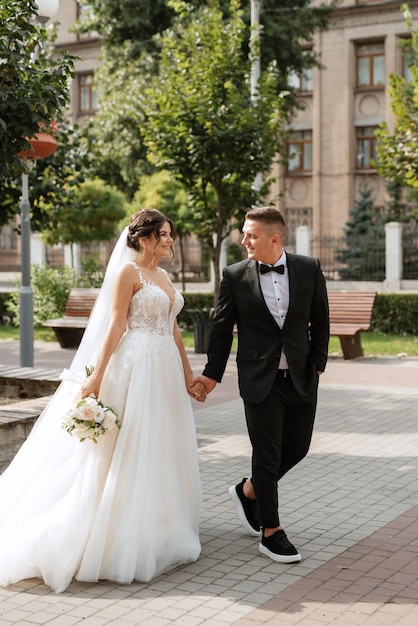 Foto lo sposo in abito marrone e la sposa in abito bianco
