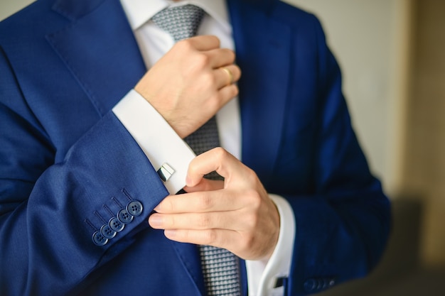 Groom or businessman fasten cufflink