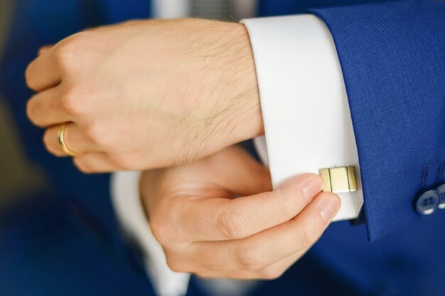 Groom or businessman fasten cufflink