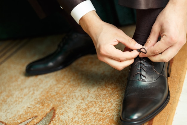 Groom dresses and binds shoes