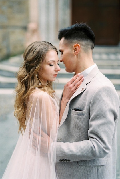 Groom embraces bride in front of the basilica of santa maria maggiore bergamo italy