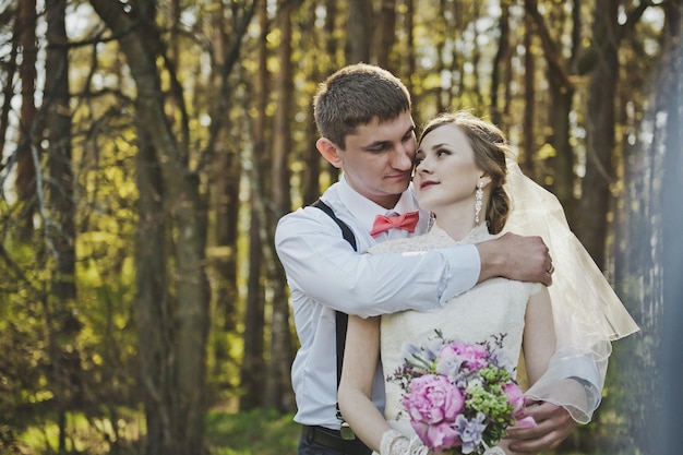 The groom embraces the brides shoulders 4069