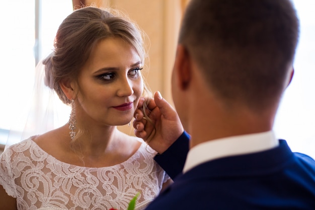 The groom gently strokes the bride's cheek. meeting of the bride and groom