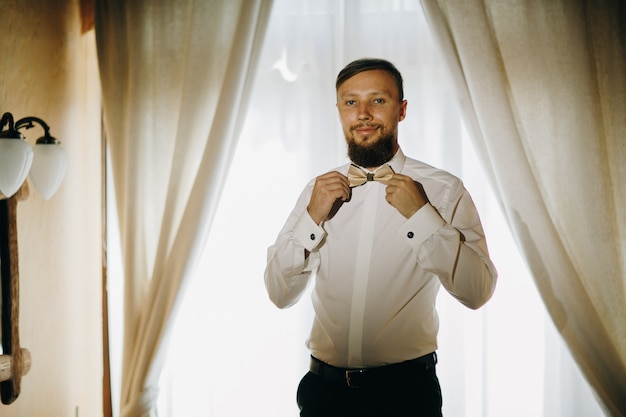 Groom getting dressed in the room