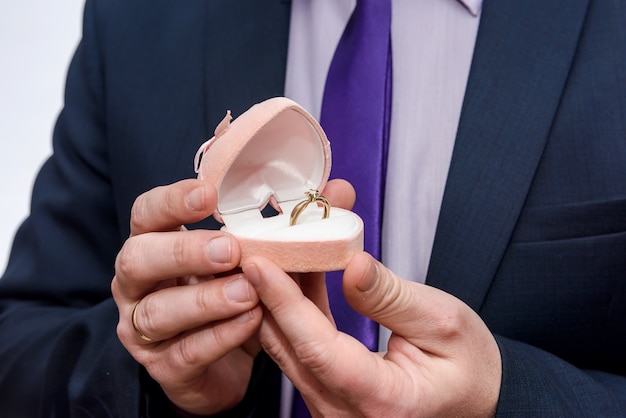 Groom gives the wedding ring in red box