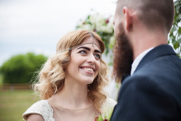 Groom hipster looks in the eyes of his beautiful bride, style rustic-close-up