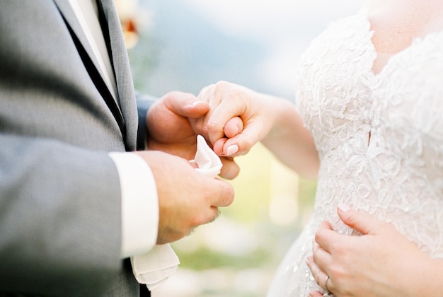 Groom holding bride hand closeup