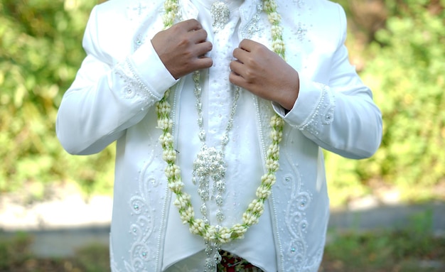 Groom Holding Jasmine and Magnolia Flower Necklace