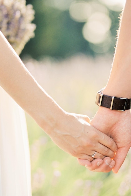 Groom holds bride hand Closeup Cropped