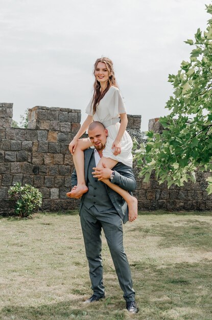 the groom holds the bride on his shoulders