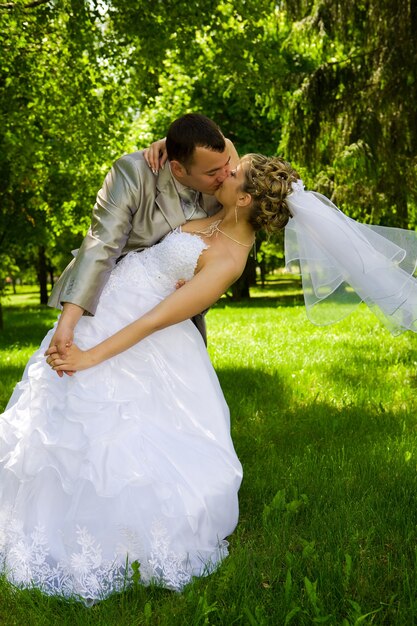 Groom holds the bride in park