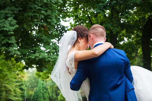 Groom holds his beautiful and happy bride