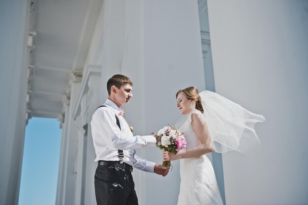 The groom hugging the bride with the white columns 3886