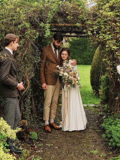 The groom hugs the bride after the wedding ceremony. Wedding ceremony in the garden