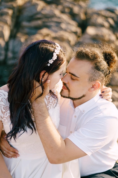 Lo sposo abbraccia la sposa seduta tra le sue braccia