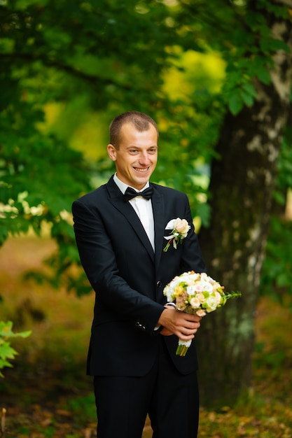 The groom is holding a wedding bouquet