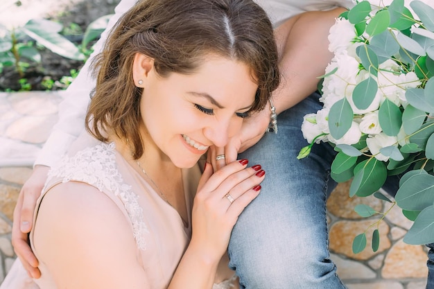 The groom is sitting on a park bench The bride rested her head on the groom's lap Wedding concept