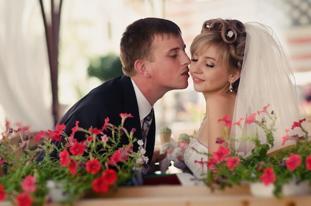 Photo the groom kisses the bride in a beautiful cafe