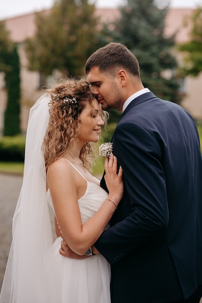 the groom kisses the bride on the forehead