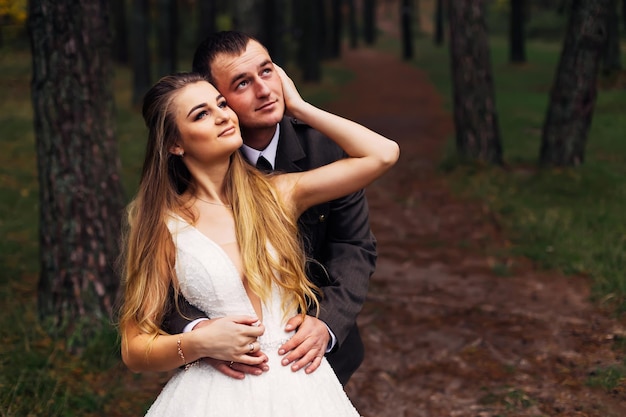 Groom in military uniform hugs the bride from the back side new